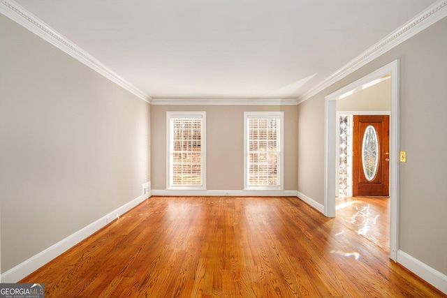 empty room with wood-type flooring and crown molding