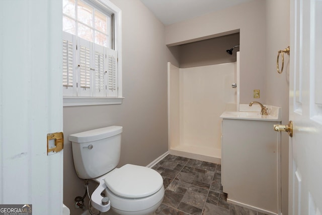 bathroom with walk in shower, vanity, and toilet