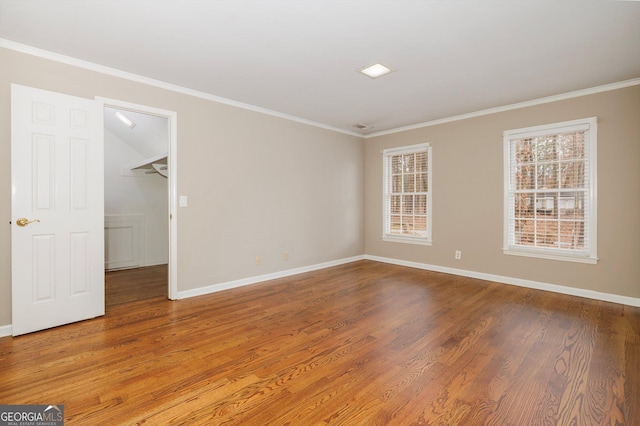 empty room with crown molding and wood-type flooring