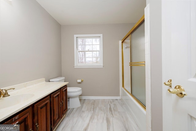 full bathroom featuring vanity, bath / shower combo with glass door, and toilet