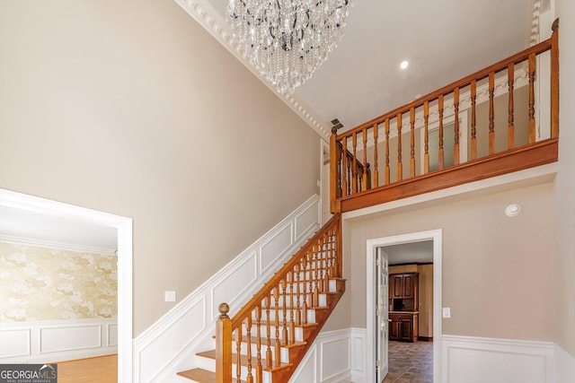 stairway with a high ceiling and an inviting chandelier