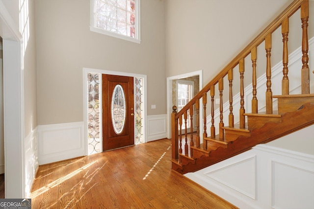 entryway with hardwood / wood-style floors and a high ceiling