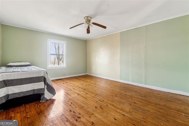 bedroom with ceiling fan, crown molding, and wood-type flooring