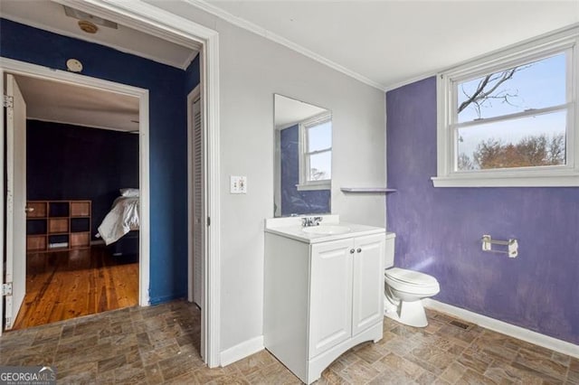 bathroom featuring crown molding, vanity, a healthy amount of sunlight, and toilet