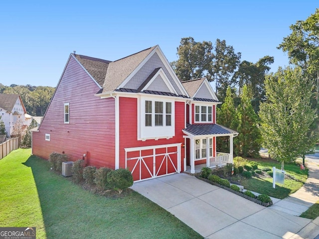 view of front of property featuring central AC, covered porch, a front yard, and a garage