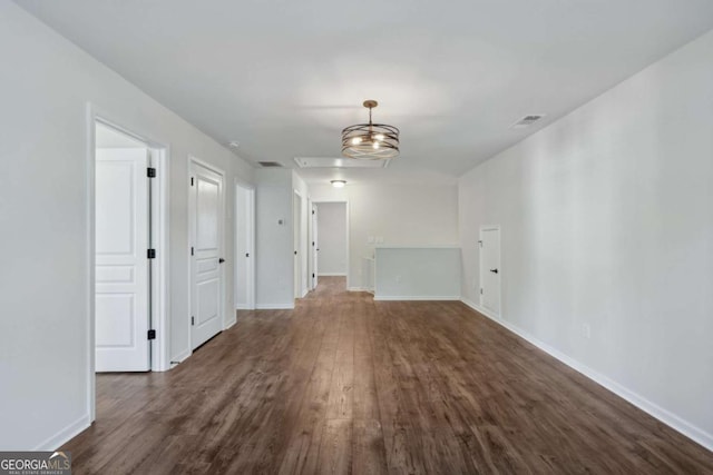 unfurnished room with dark hardwood / wood-style floors and an inviting chandelier