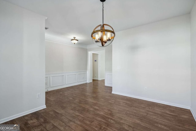 unfurnished room with crown molding, dark wood-type flooring, and an inviting chandelier