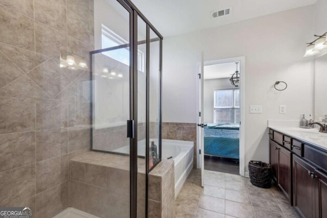 bathroom with shower with separate bathtub, vanity, and tile patterned floors