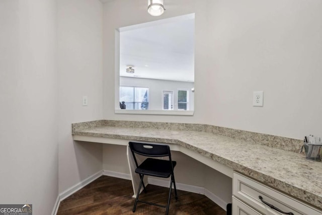 office space with dark hardwood / wood-style flooring and built in desk