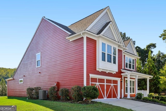 view of home's exterior with a lawn, a garage, and central air condition unit