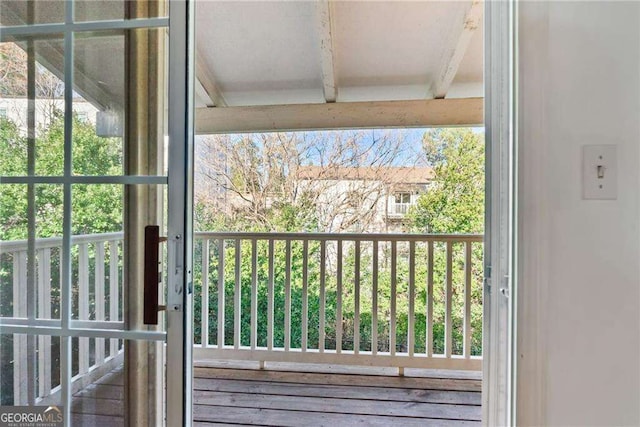 doorway to outside with beamed ceiling