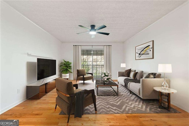 living room with ceiling fan, a textured ceiling, and hardwood / wood-style flooring