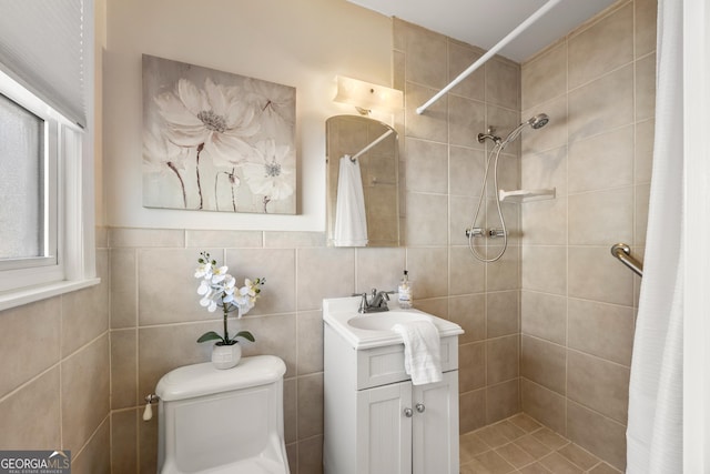 bathroom with walk in shower, vanity, toilet, and tile walls