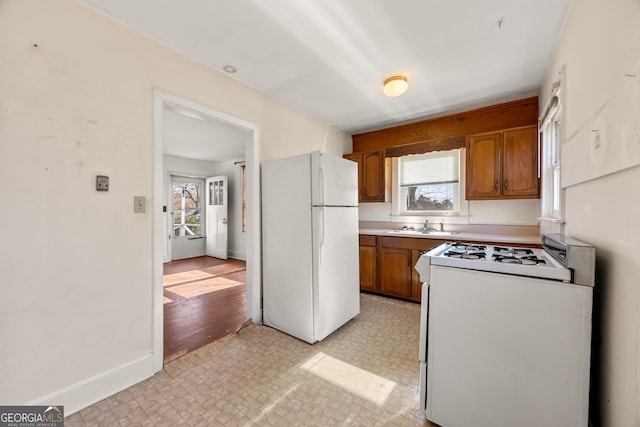 kitchen featuring sink, a wealth of natural light, and white appliances