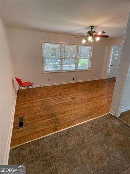 unfurnished room featuring ceiling fan and dark hardwood / wood-style flooring