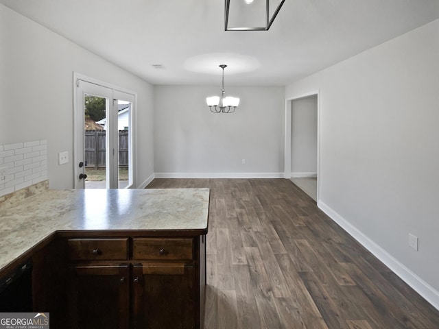 unfurnished dining area featuring dark wood-type flooring and a notable chandelier