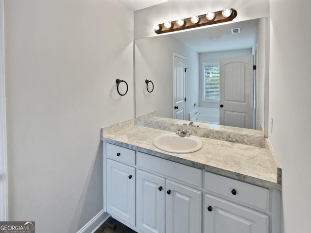 bathroom with vanity and a washtub