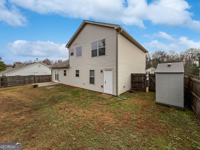 back of house featuring a lawn and a storage shed