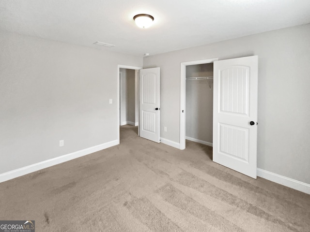 unfurnished bedroom featuring light carpet and a closet