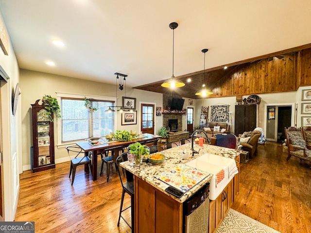 kitchen featuring a kitchen bar, dark hardwood / wood-style floors, a center island with sink, and sink