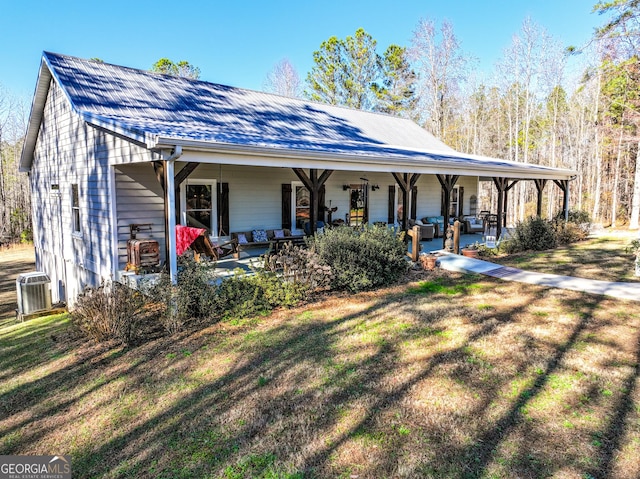 view of front of house featuring covered porch, a front lawn, and central air condition unit