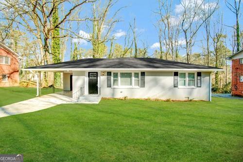 single story home featuring a carport and a front yard