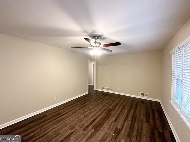 empty room with ceiling fan and dark wood-type flooring