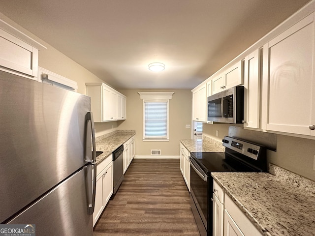 kitchen featuring light stone countertops, appliances with stainless steel finishes, dark hardwood / wood-style flooring, and white cabinets