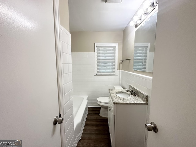 bathroom featuring vanity, wood-type flooring, tile walls, and toilet