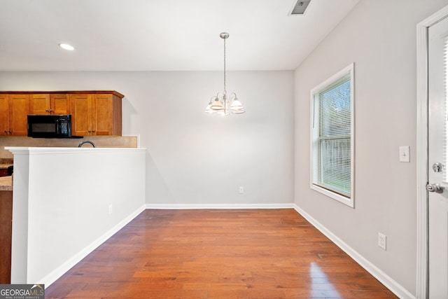 kitchen with pendant lighting, a notable chandelier, and light hardwood / wood-style flooring