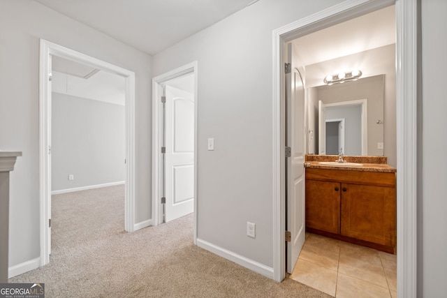 hallway with sink and light colored carpet