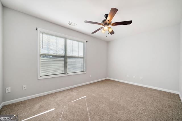 carpeted spare room featuring ceiling fan