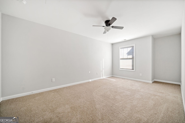 carpeted spare room with ceiling fan