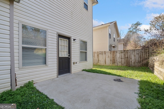 doorway to property with a lawn and a patio area