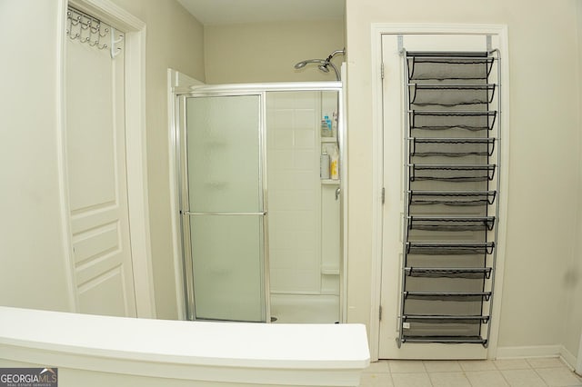 bathroom with tile patterned flooring and a shower with door