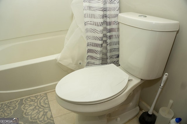 bathroom with tile patterned floors, toilet, and shower / bath combo with shower curtain