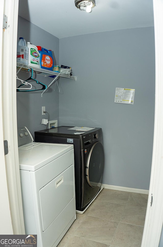 clothes washing area with independent washer and dryer and light tile patterned floors