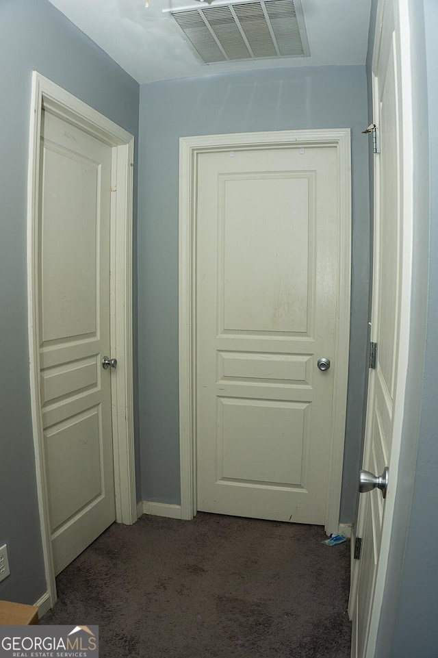 hallway featuring dark carpet