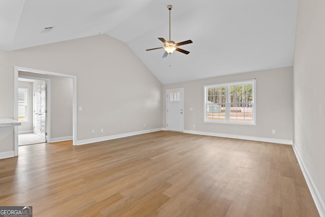 unfurnished living room featuring ceiling fan, high vaulted ceiling, and light wood-type flooring