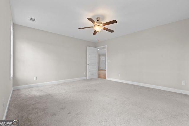 unfurnished room with light colored carpet and ceiling fan