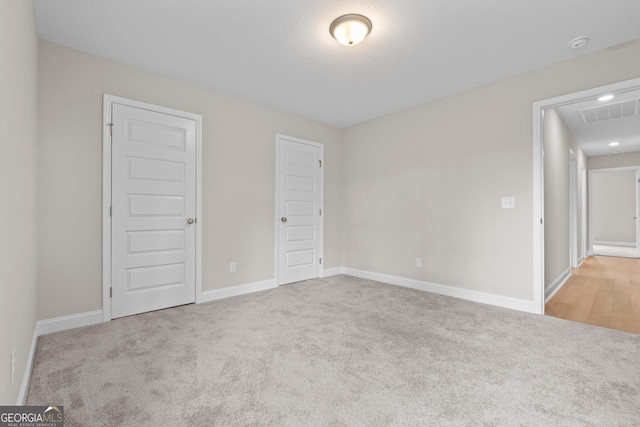 unfurnished bedroom featuring light carpet