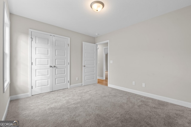 unfurnished bedroom with carpet flooring and a closet