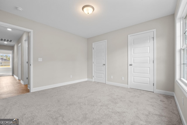 unfurnished bedroom featuring light carpet