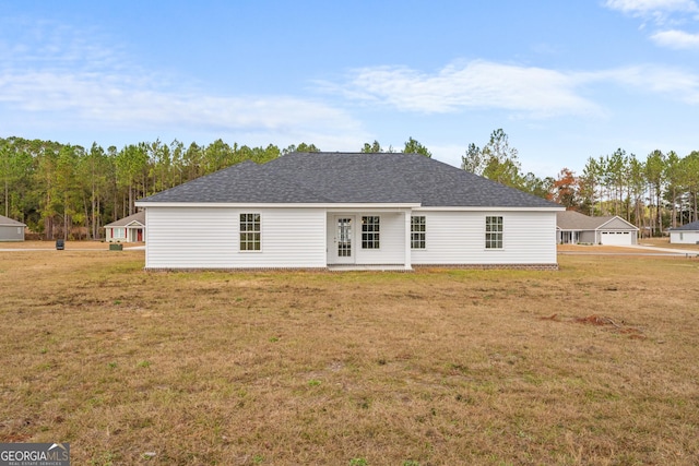 back of property featuring a lawn and a garage