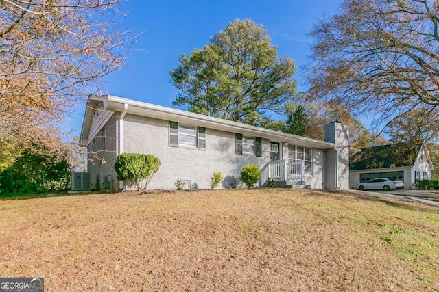 ranch-style house with a front yard and central AC unit