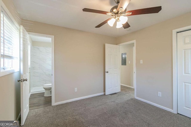 unfurnished bedroom featuring carpet flooring, ensuite bath, and ceiling fan