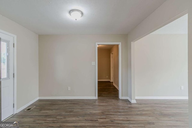 empty room with dark hardwood / wood-style flooring