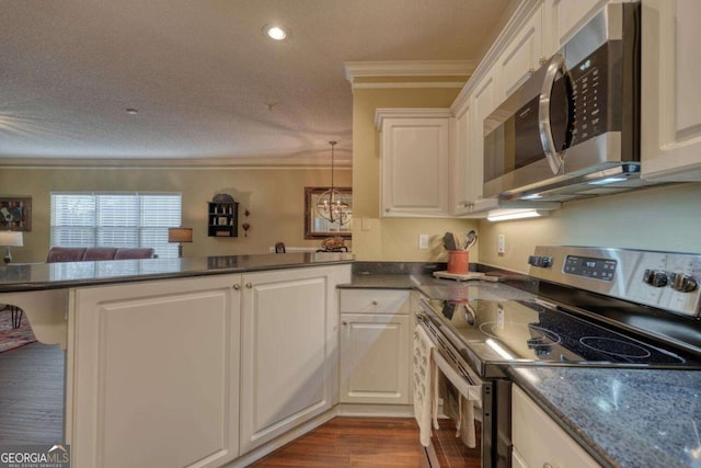 kitchen with kitchen peninsula, white cabinetry, ornamental molding, and appliances with stainless steel finishes