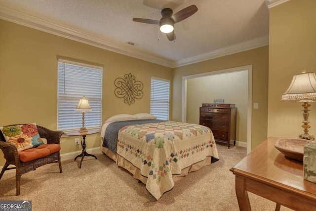 carpeted bedroom with ceiling fan, ornamental molding, and a textured ceiling