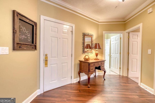 entryway with a textured ceiling, hardwood / wood-style flooring, and crown molding